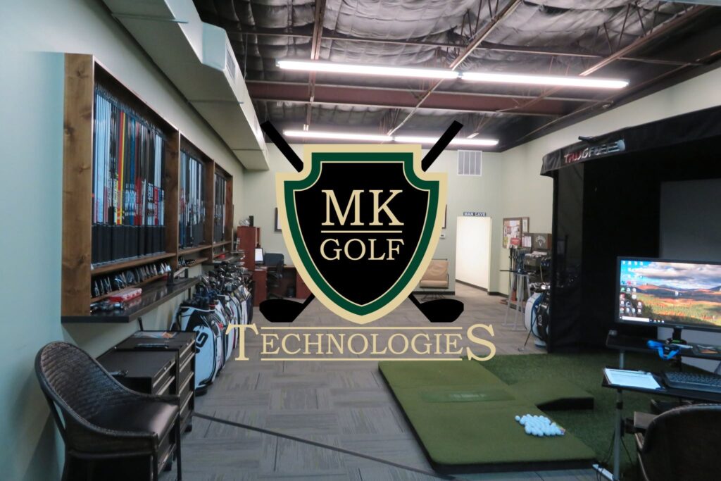 Indoor golf showroom with green practice mats, wall of clubs on the left, and a large MK Golf Technologies crest centered in the foreground.